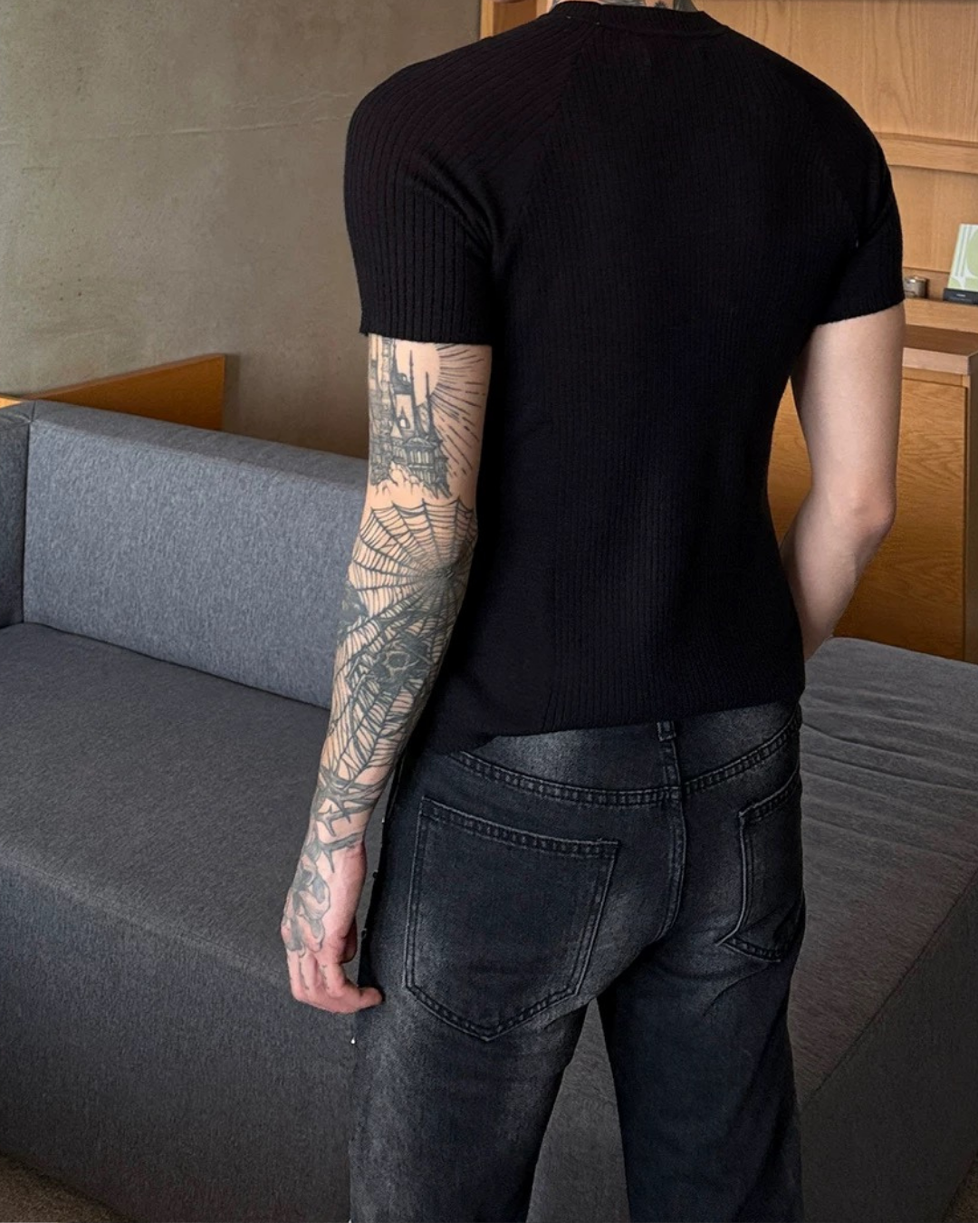 黒のリブニット半袖Tシャツ。縦方向の細かなリブ編み素材で、ハイネック気味のクルーネック仕様。タイトなボディシルエット。