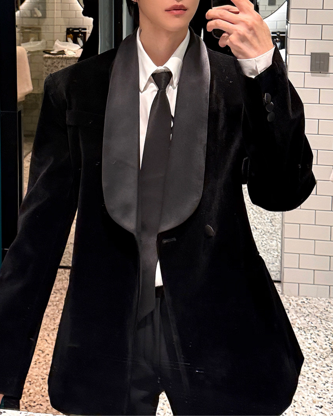 メンズの鏡越しに写した黒ベルベットのジャケット。幅広のサテンのショールカラーと袖口の三つ釦、白シャツに黒サテンのタイ。