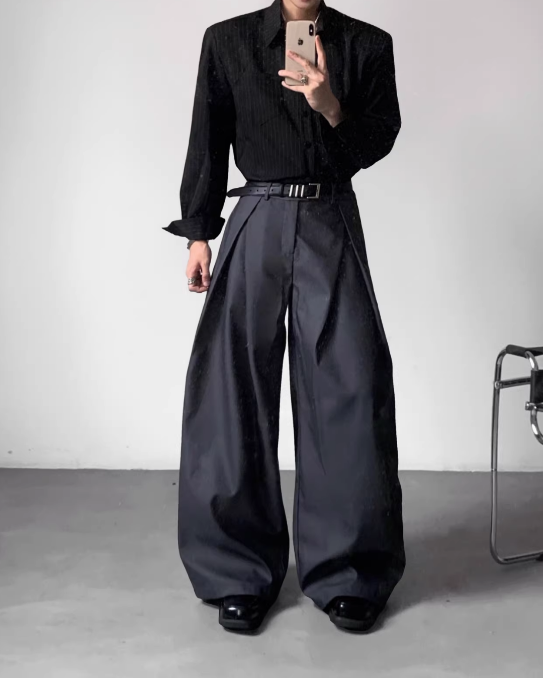 メンズの黒ピンストライプシャツジャケットと、黒のワイドスラックス。ハイウエスト、両サイドに深いプリーツ、幅広ベルト付き。
