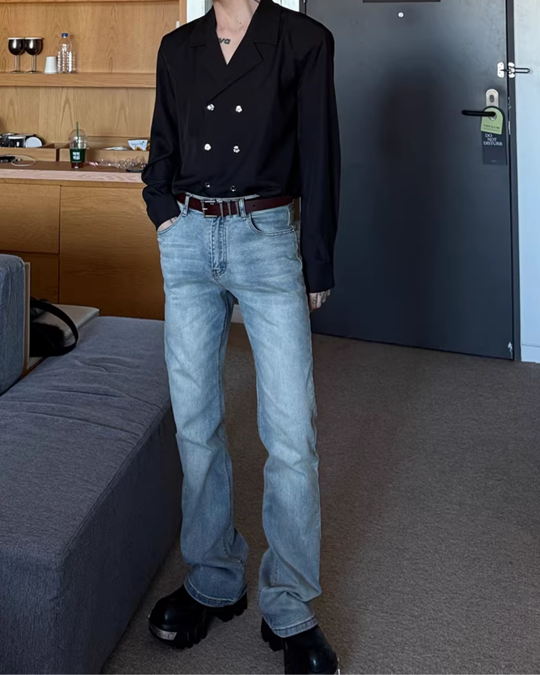 メンズの黒のダブルブレストシャツにデニムとレザーブーツの全身。身頃は短めで肩が張り、袖は長い。