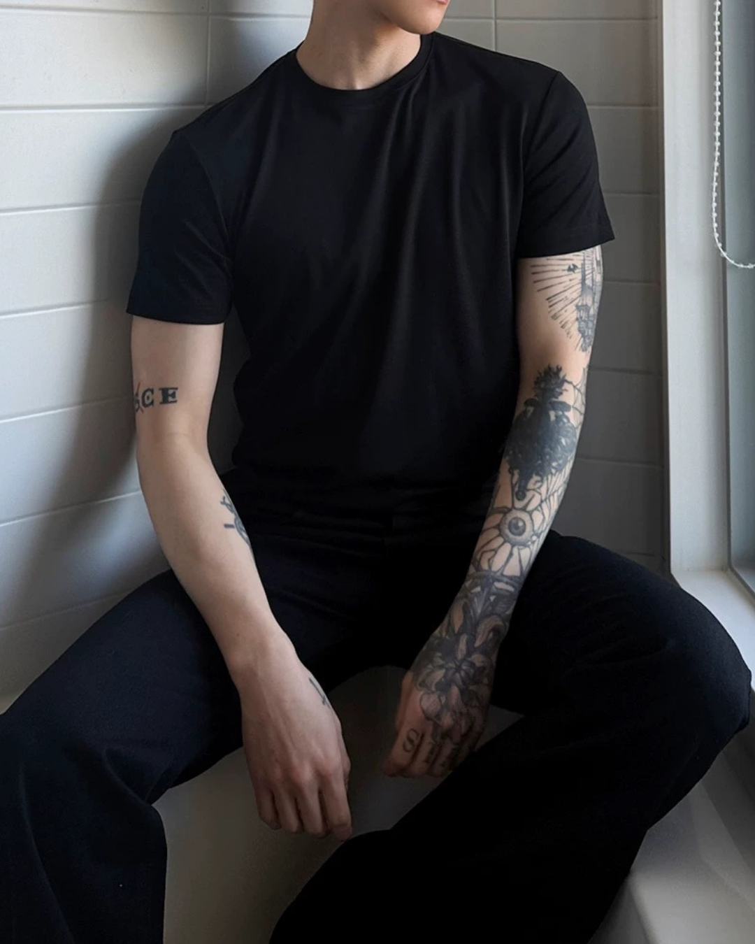 黒のクルーネック半袖Tシャツ。コットン素材でタイトなシルエット、胸から腰に沿ったフィット感。
