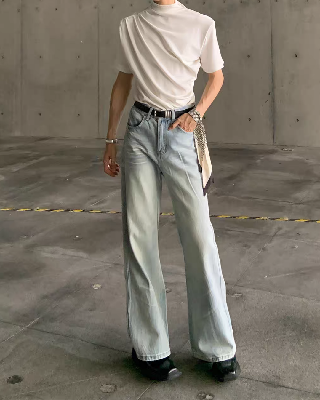 メンズの淡いブルーのデニムパンツを正面から全身で見た着用。ストレート寄りの緩やかなフレアで、膝周りにヒゲ加工が入る