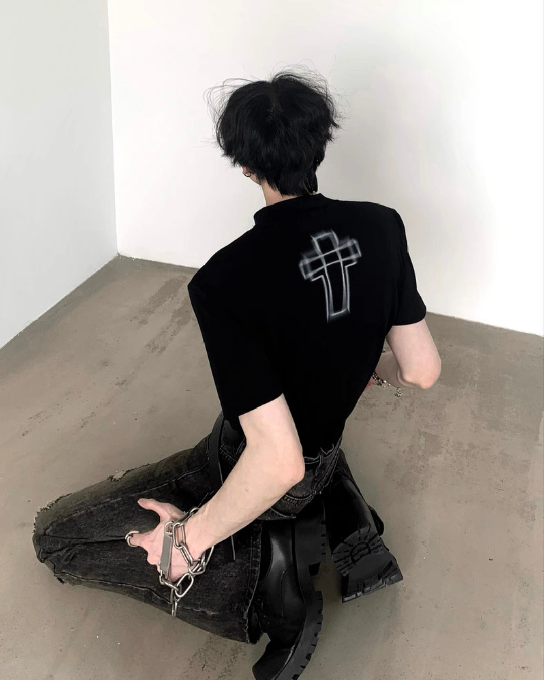 黒のクルーネックTシャツ。背中に十字架のグラフィックプリント。半袖でクロップ丈。