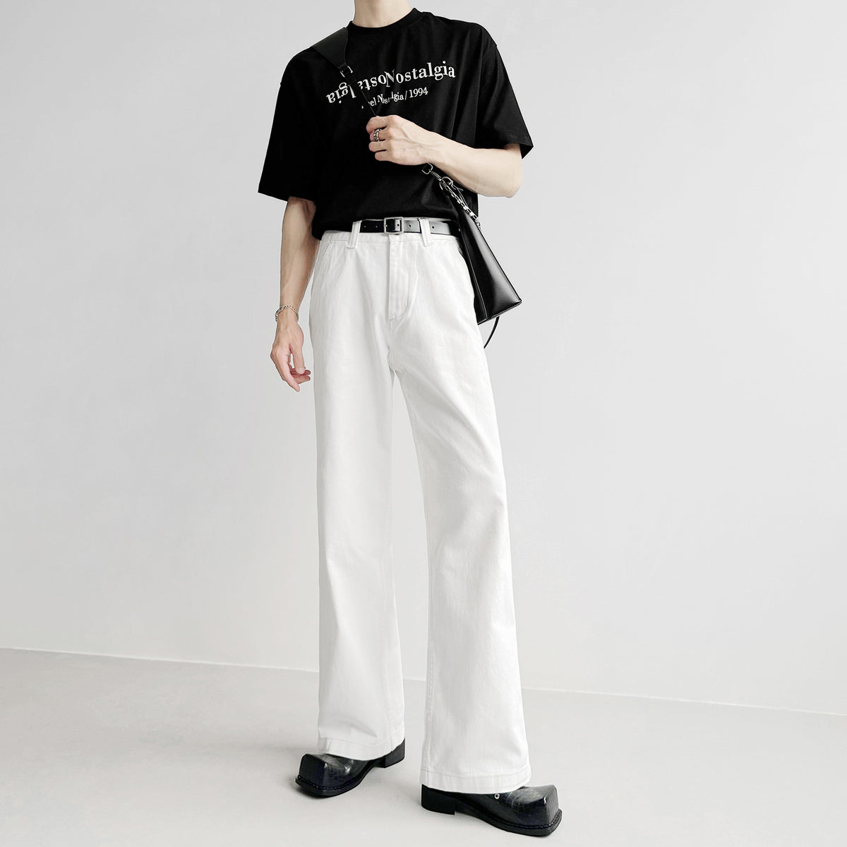 白デニムのワイドパンツ。腰位置高めでタック入り、ストレートシルエット。黒ベルト付き。
