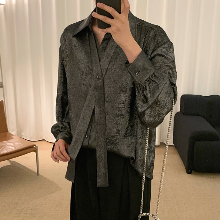 グレーのタイデザインシャツ。光沢のある素材で、開襟とボタン留め、長袖。ゆったりしたシルエット。