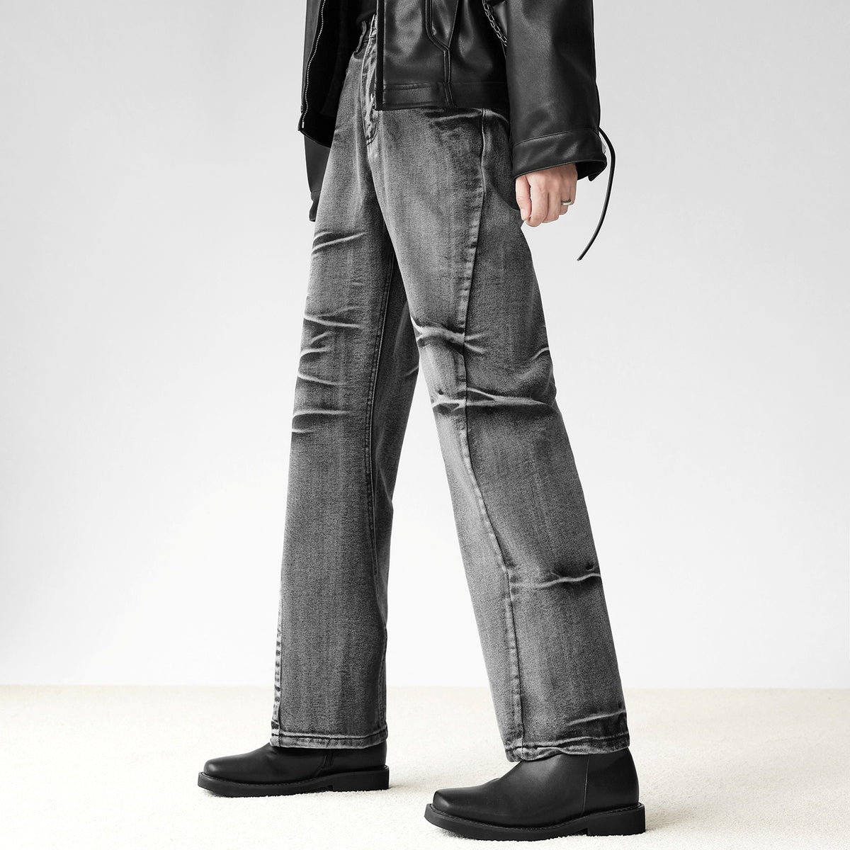 メンズのグレー系デニムのワイドストレートパンツ。左右非対称の白ステッチラインと立体的なタック加工が特徴。