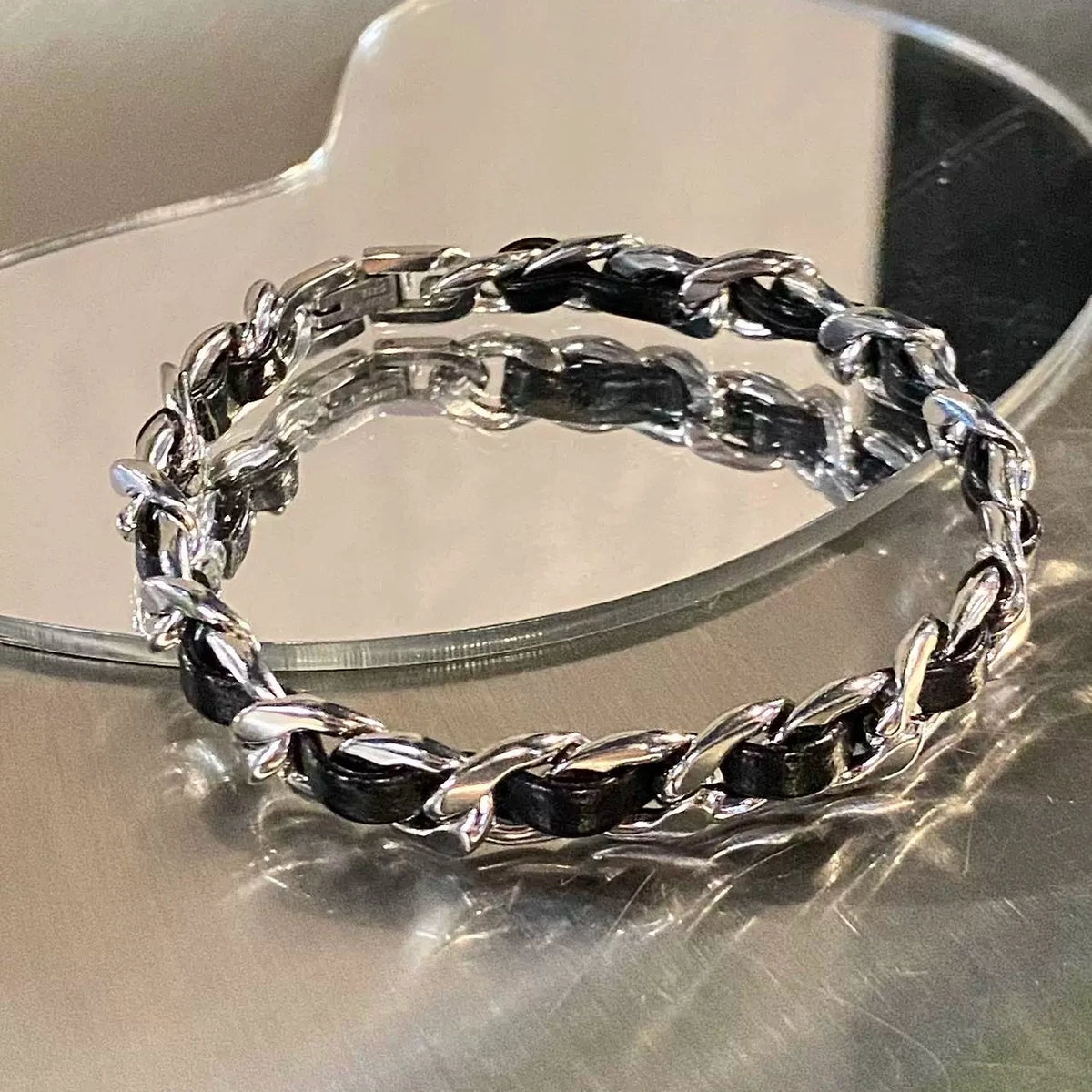 メンズの黒レザーと銀色チェーンを交互に編み込んだブレスレット。金具留め式。