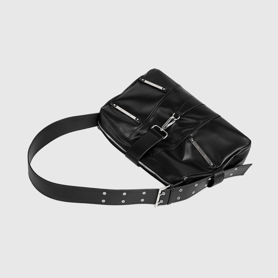 黒レザーのショルダーバッグ。金属プレートとスタッズ装飾、複数のジッパーポケット、メタルバックルと鋲留めベルト付き。