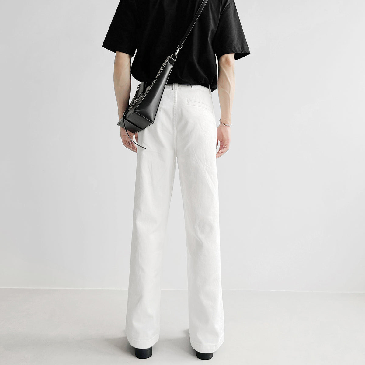 白デニムのルーズフィットパンツ。ハイウエスト、裾まで真っすぐのストレートシルエット。黒Tシャツとの組み合わせで着用