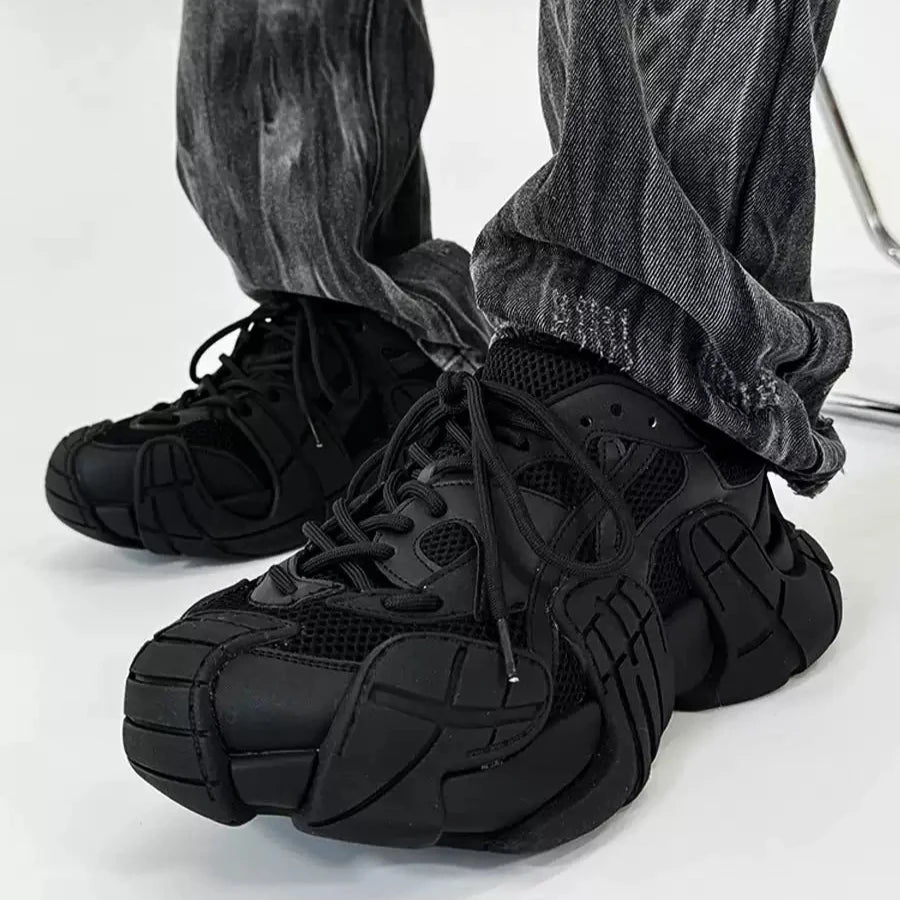 黒のメッシュ切り替えデザインスニーカー。厚底ソールと紐留め。グレーのデニムパンツを合わせた着用写真。