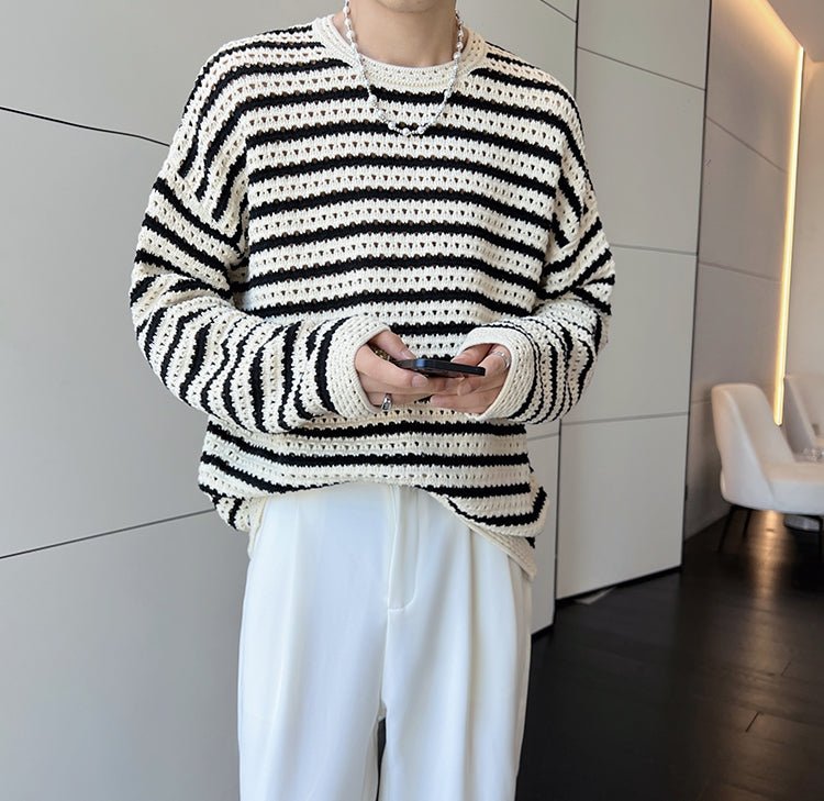白と黒のボーダー柄ニット。透かし編み素材で長袖、クルーネック。オーバーサイズなリラックスシルエット。
