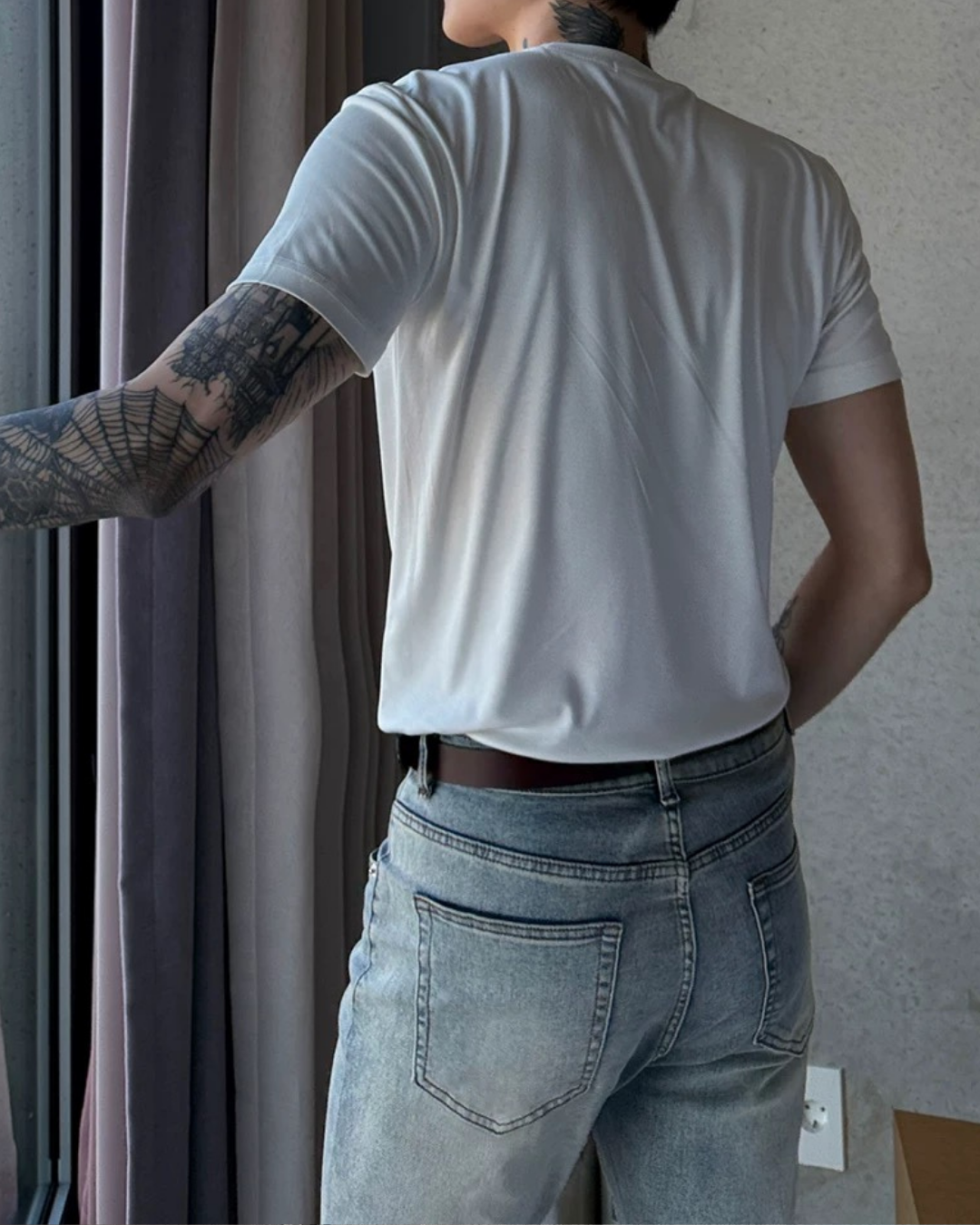 白色の半袖Tシャツ。フィット感のあるシルエットで、背面からの着用写真。