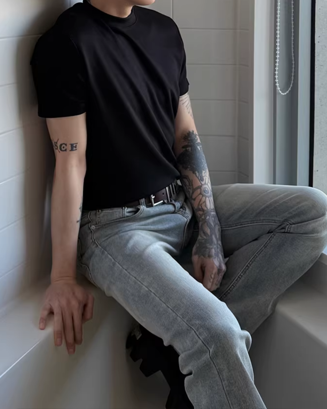 黒のクルーネック半袖Tシャツ。素材はコットンのような伸縮性のあるカットソー素材。タイト気味のシルエット。