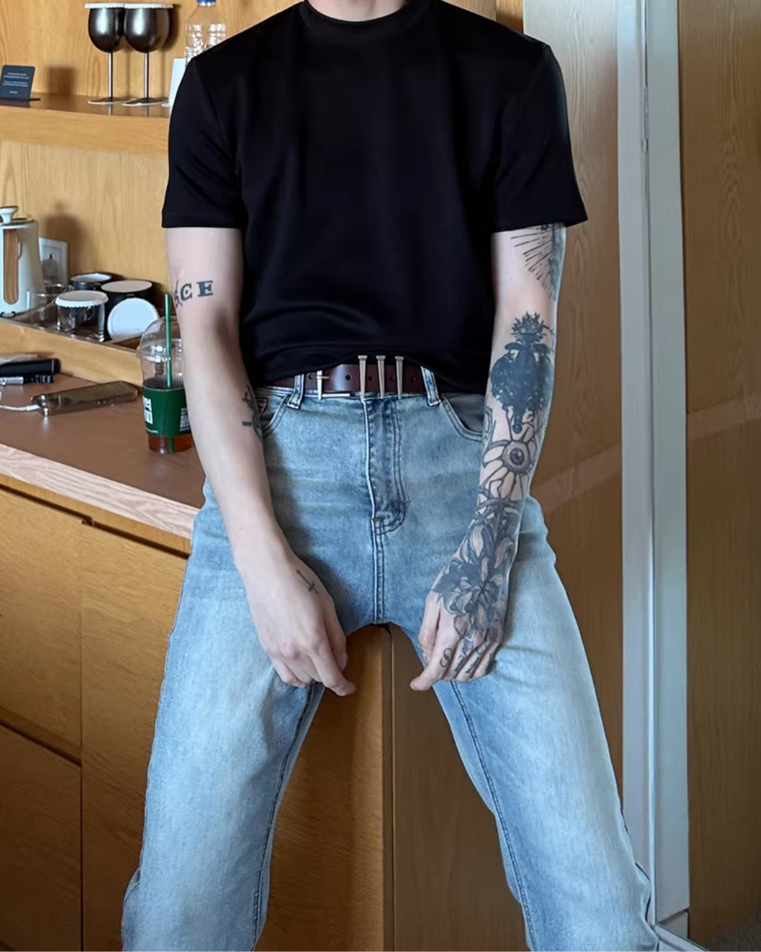黒色のクルーネック半袖Tシャツ。厚地のコットン素材でリラックスシルエット。ライトブルーのストレートデニムと合わせた着用画像。