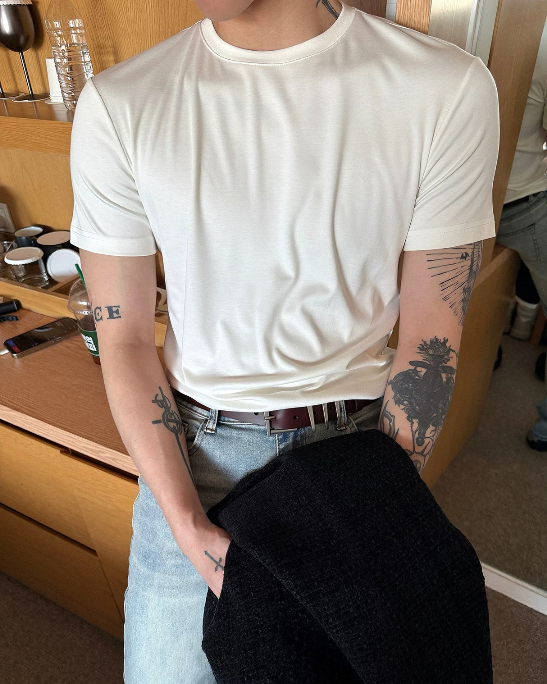 オフホワイトの半袖クルーネックTシャツ。綿素材でスリムなシルエット、袖口と裾はリブ仕上げ。