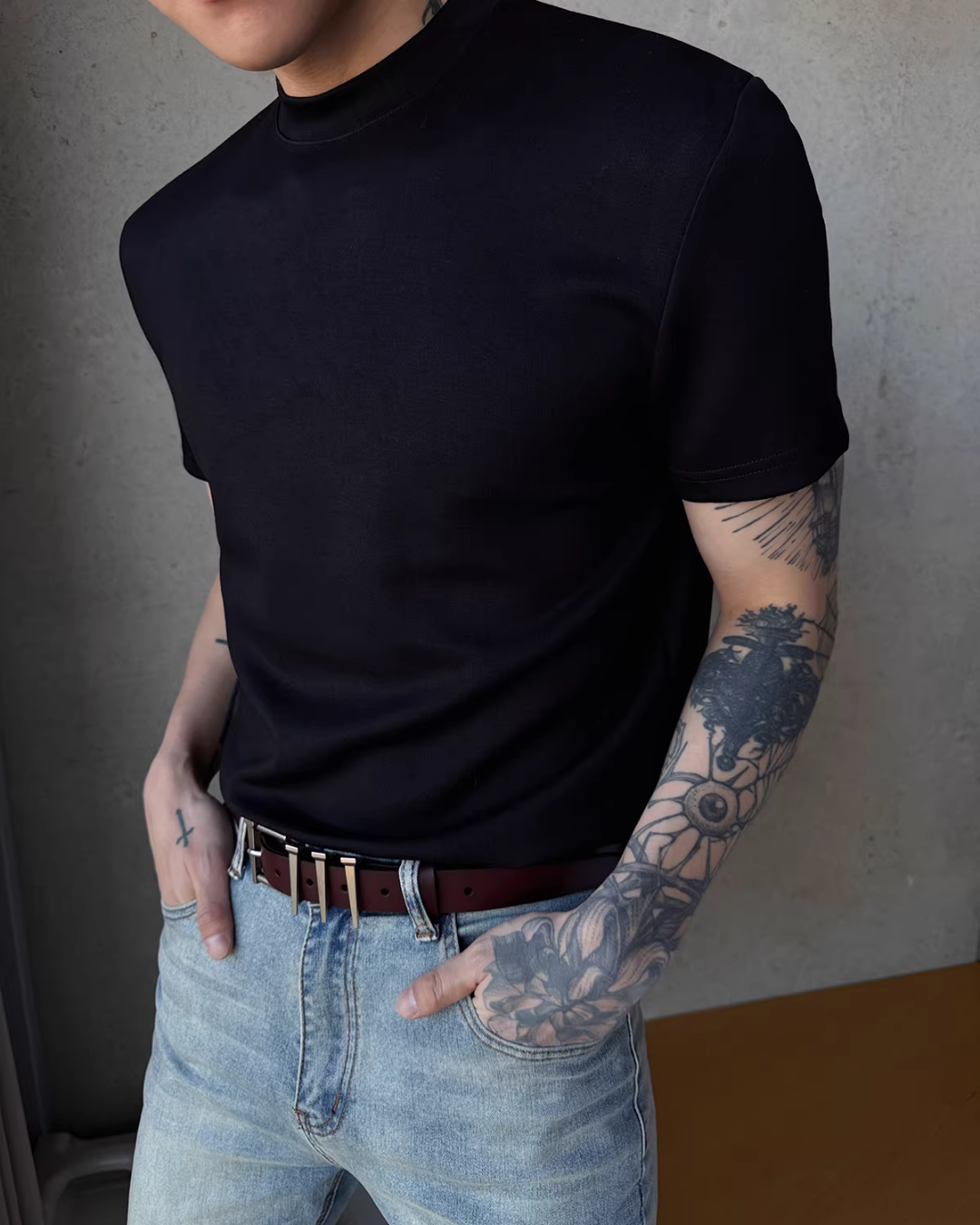 黒いハイネックTシャツ。半袖で首まで詰まったネックライン、リラックスしたシルエット。