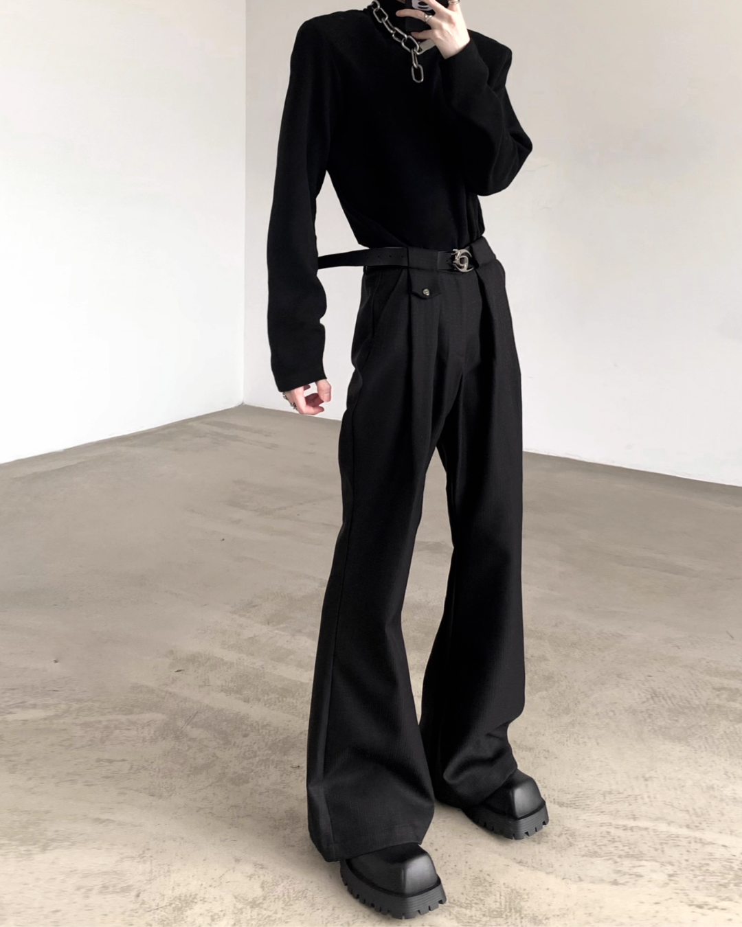黒のハイネックカットソー。長袖でオーバーサイズシルエット。黒のベルト付きワイドパンツと合わせた全身着用画像。