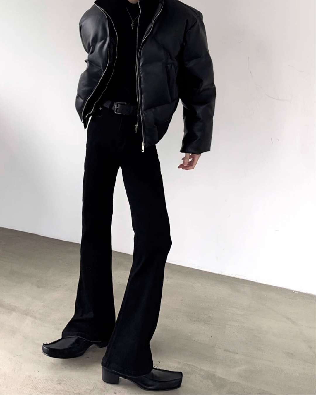 メンズの黒デニムのハイウエストフレアパンツ。ベルト付きで、裾に向けてウイドに広がるシルエット。