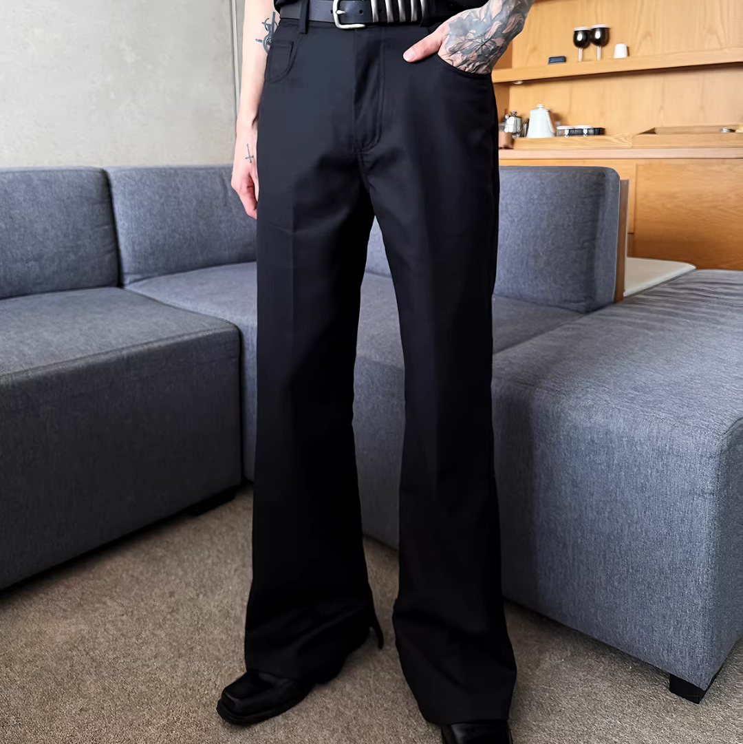 黒いストレートレッグパンツ。ハイウエスト仕様で、直線的なシルエットと長めの着丈が特徴。ベルト付き。