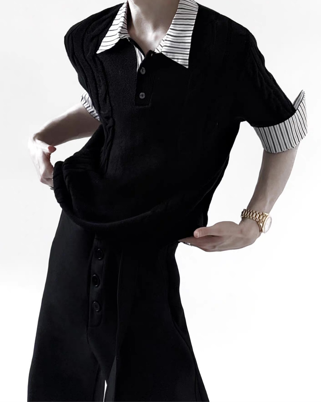 黒いニットトップス。白黒ストライプシャツを重ね着した衿と袖口。前身頃にボタン付き。