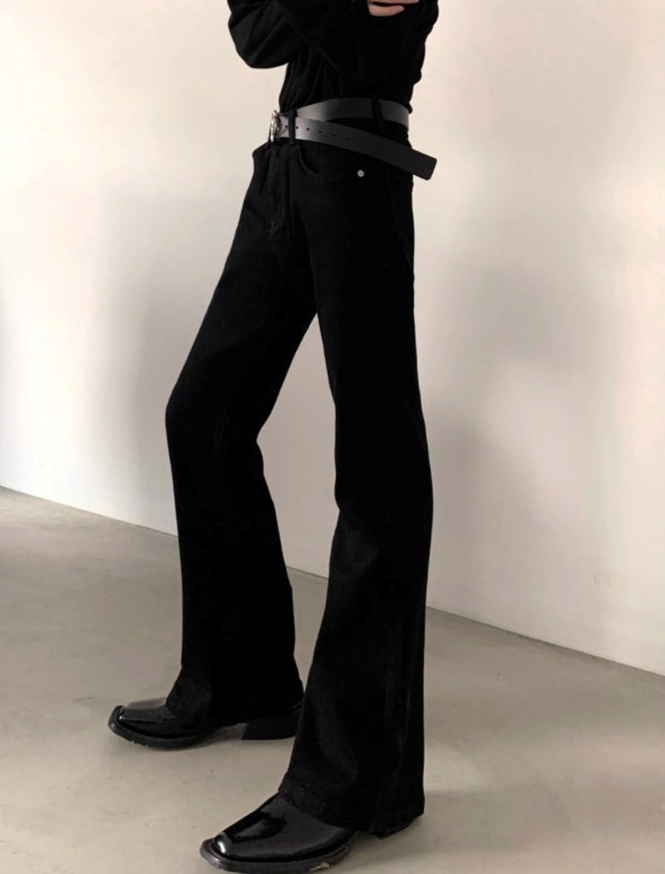 メンズの黒のフレアパンツ。ハイウエスト、幅広のベルト付き。裾に向かって広がるシルエット。
