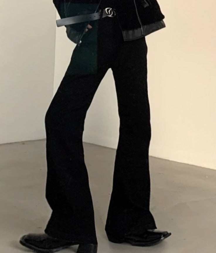 メンズの黒のフレアパンツ。腰部にレザーベルト付き。裾に向けて広がるシルエットで、先端は細く絞られた形状。
