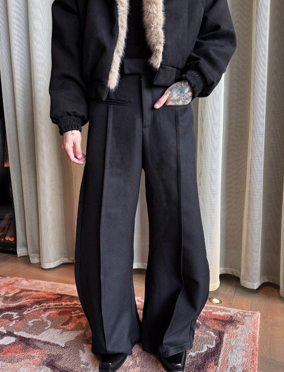 黒いドレープスラックス。ハイウエスト、センター線による縦ドレープが特徴。ワイドシルエット、裾ロング。