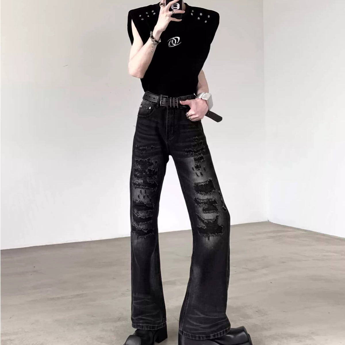 黒のスタッズ装飾ノースリーブトップス。肩にスタッズが配置され、胸部にロゴ刺繍が施されている。