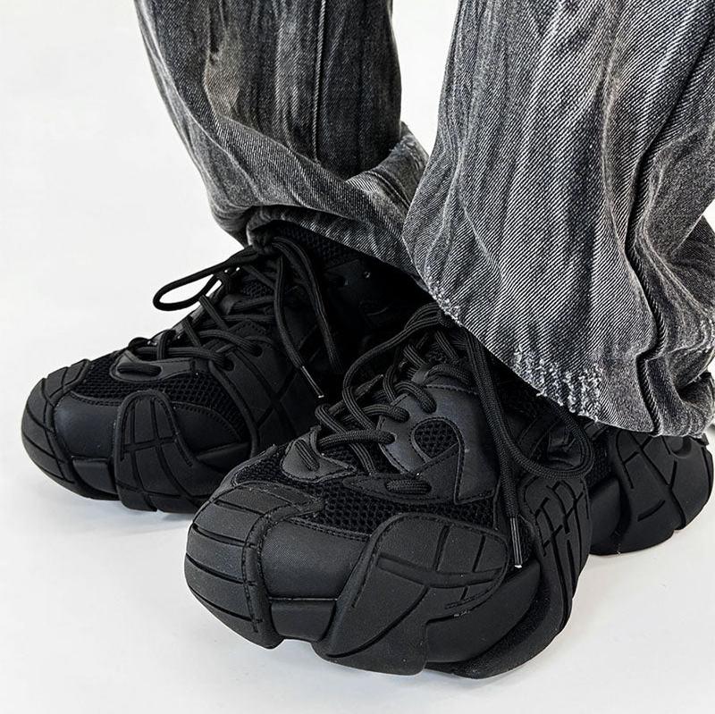 黒のメッシュ切替スニーカー。厚底ソールと紐穴が特徴。グレーデニムパンツとの着用例。