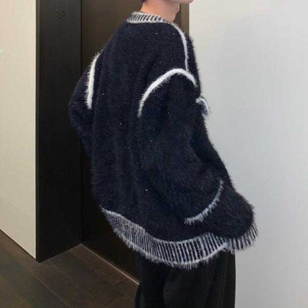 メンズの黒のモヘアタッチのカーディガンを横から見た着用姿。白の縁取りが肩と袖に入り、裾は白黒縞のリブ仕上げ。ゆったりしたシルエット。