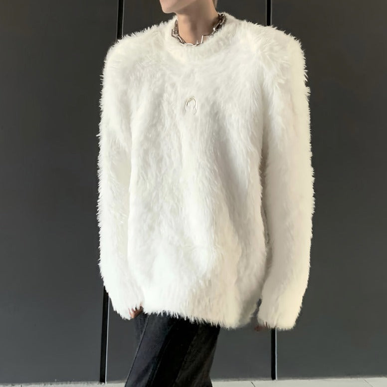 メンズの白のシャギーニットの全身。クルーネックのオーバーサイズで肩に張りがあり、胸元に小さな三日月形の金具が付く。