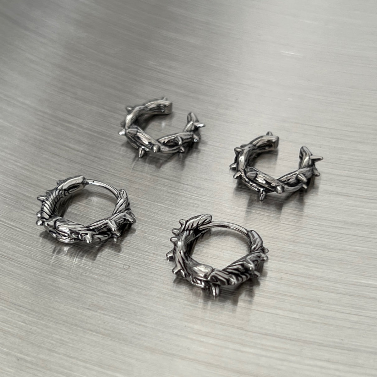 シルバートーンの金属製リング。棘状の突起が全体に装飾されたボルダーデザイン。4個セット。