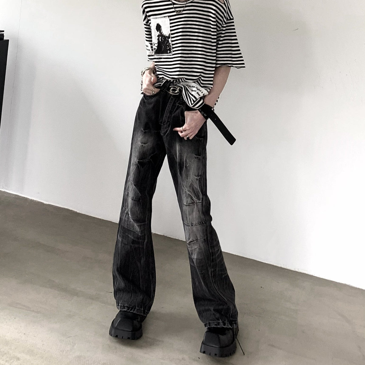 メンズの立ち姿の正面全身。ボーダーTシャツに黒の色落ちデニム、膝に横ステッチを入れ、厚底の黒シューズを履く。