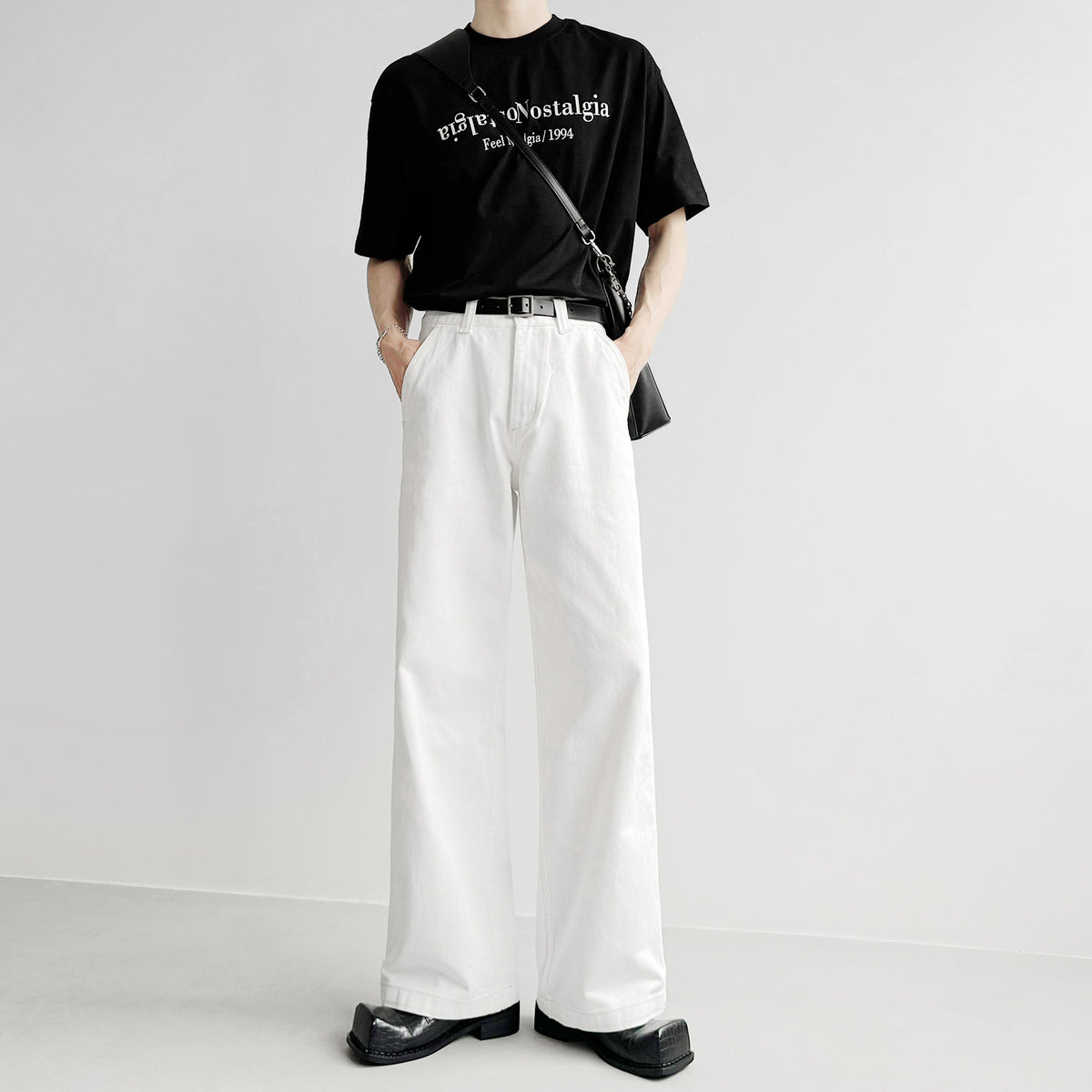 白いルーズデニムパンツ。ハイウエスト、タック入り、ストレートシルエット。黒ベルト付き。