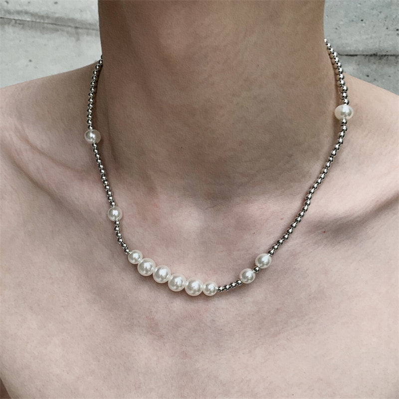 メンズのシルバー色の小ビーズとホワイトパールを交互に配した短めのネックレス。センター部分にパール玉が集中し、両側へ向かってビーズが散在する。