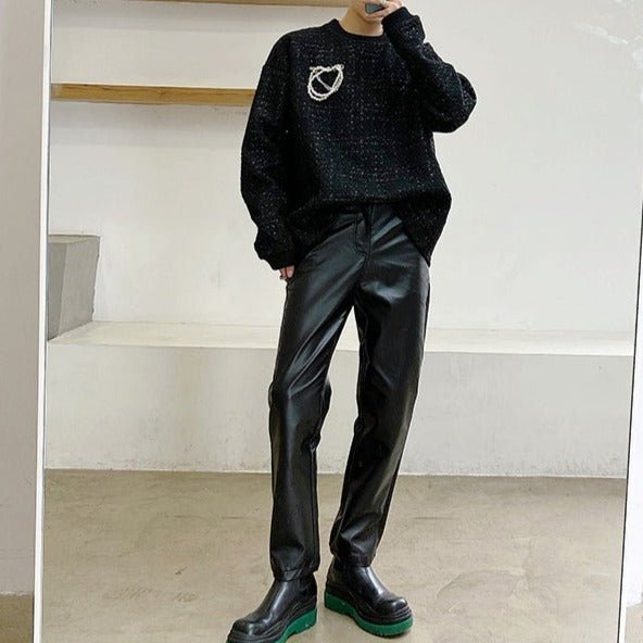 メンズの黒のニット素材ハート刺繍付きクルーネックセーター。オーバーサイズのシルエットで袖口はリブ仕上げ。