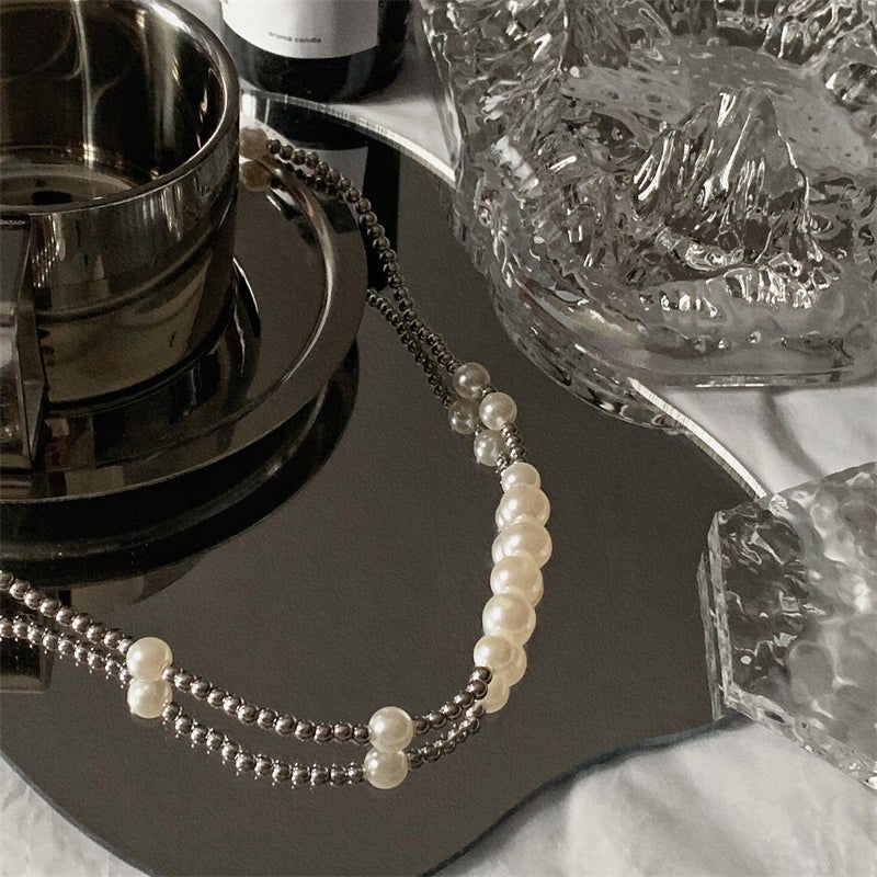 白いパールビーズとシルバートーンのメタリックビーズを交互に配した、華奢なチェーンネックレス。